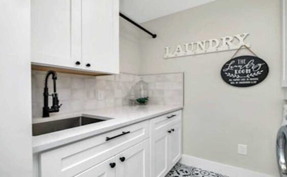 Blog Modern laundry room with white cabinets, sink, and washer.