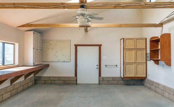 Blog Organized garage workshop with cabinets, shelves, and workbench.